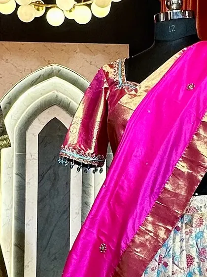 A glimpse of our bespoke lehengas in the studio. This floral brocade lehenga is paired with a shimmering pink blouse and dupatta, showcasing a complete outfit ready for an engagement ceremony.