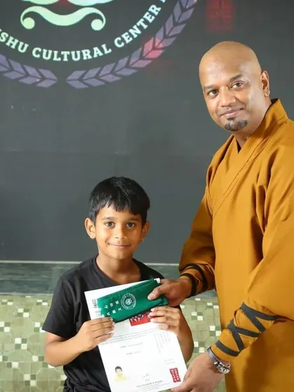A proud moment for a young warrior receiving his certificate and new belt. This recognizes his hard work and dedication on his martial arts journey.