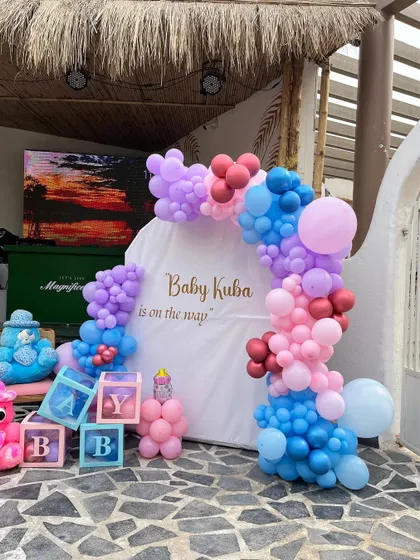 A colorful and fun baby shower setup for "Baby Kuba," featuring "BABY" blocks and a mix of pink, blue, and purple balloons.