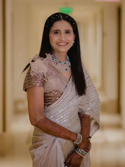 A full-length view of the bride's sister. Her elegant saree and soft glam makeup create a sophisticated look.