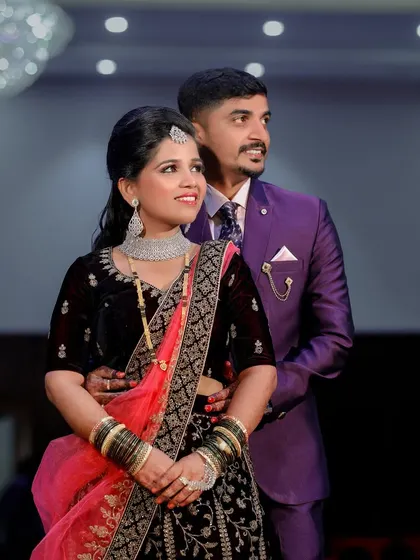 A stylish couple poses for a portrait at their reception, looking away from the camera in a candid, thoughtful moment.