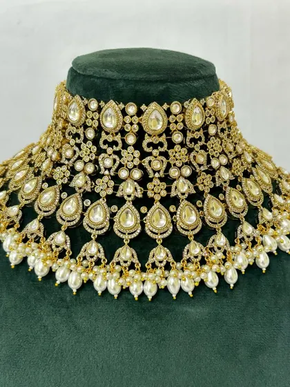 A wide bridal choker made with Kundan stones and pearl drops. This popular rental piece creates a bold and beautiful neckline.