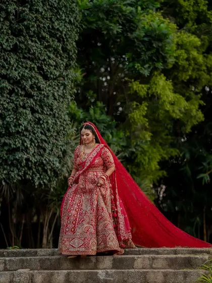A regal bride in her magnificent red lehenga. We capture the grandeur of the bridal attire, creating portraits that are both powerful and elegant.