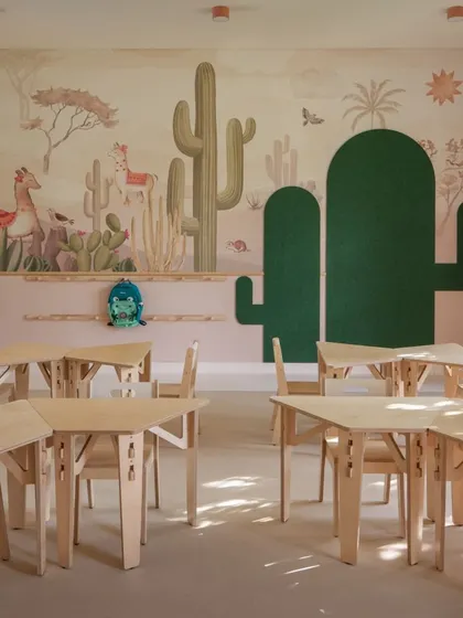 We created distinct, immersive worlds for each kindergarten level. This is a glimpse into the desert-themed classroom, where soft peach tones, cactus-shaped pinup boards, and beautiful wall murals create a warm and cohesive environment. The modular birch ply furniture allows for flexible learning setups, moving away from traditional plastic options.