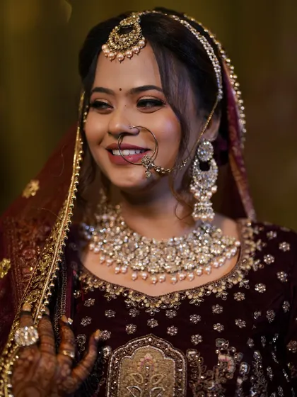 A happy bride in a deep velvet lehenga. Her smile and glowing makeup make for a perfect reception look.