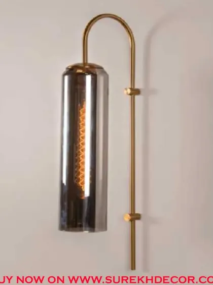 This elegant columnar wall lamp features a dusky, smoked glass shade for a more subdued and modern look. The antique brass finish provides a beautiful contrast, creating a sophisticated and moody light fixture.