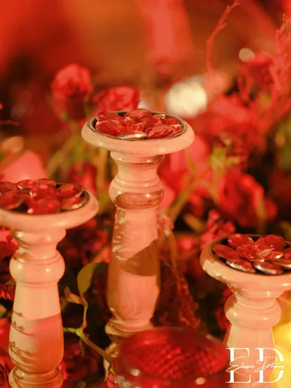 A close-up of decorative red gems on wooden pedestals, adding a touch of sparkle to the table decor.
