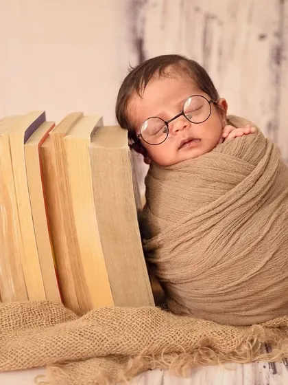 A little bookworm in the making. This adorable pose with the baby leaning against a stack of books is a highlight of the nerdy-themed shoot.