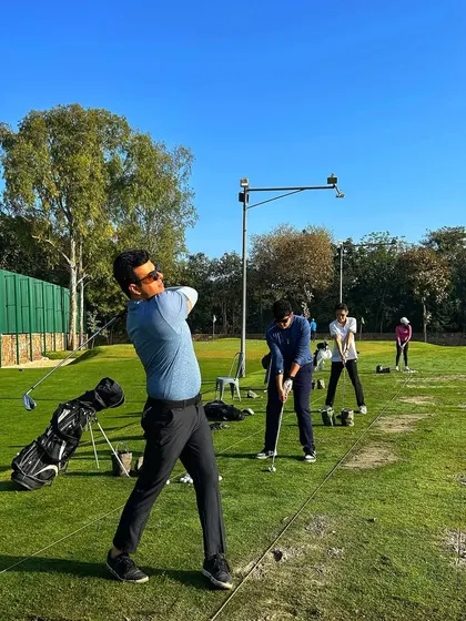 Packed bays and high energy. A golfer shows off a perfect follow-through on a busy weekend.