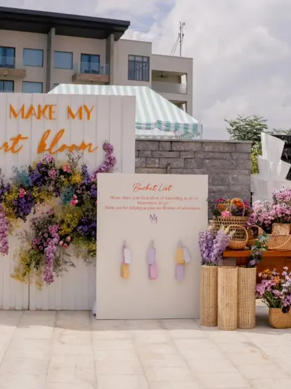 A welcome area with a 'Bucket List' activity for guests and an abundance of pastel flowers in woven baskets.