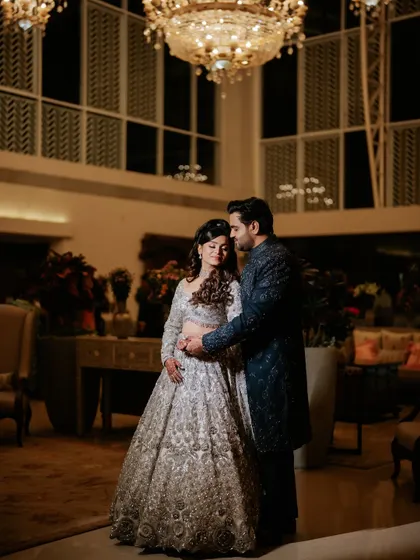 A romantic shot of the couple under the grand chandeliers of the venue. We work with the existing architecture to find the perfect spots for timeless portraits.