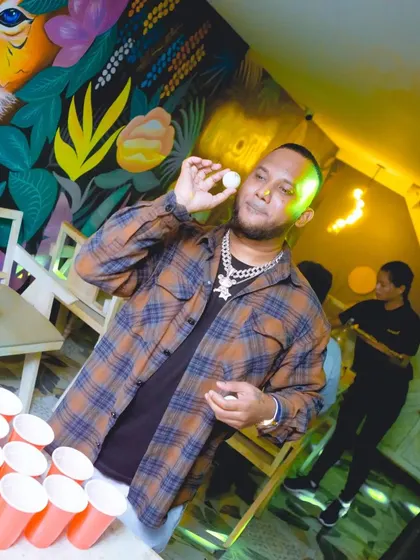 It's not just music; it's about the experience. Here I am setting up a game of beer pong, a staple at my Sweet & Sour rooftop nights to get the crowd interacting and having fun.