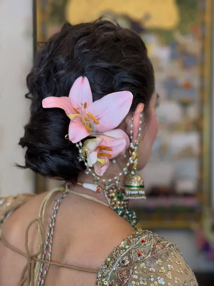 For a touch of unique color, I used fresh pink lilies to adorn this bride's messy bun. The large, elegant flowers make a beautiful statement.