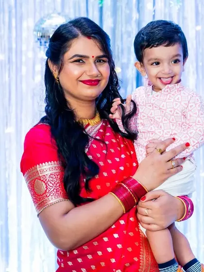A beautiful portrait of a mother and her son at his first birthday party. The shimmering blue backdrop and their coordinated outfits create a lovely and elegant look.