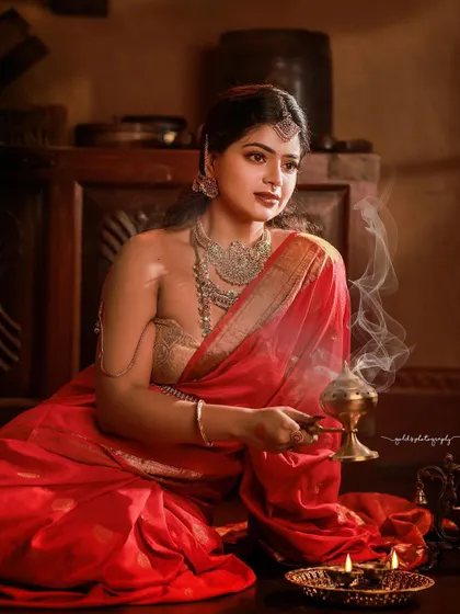 A regal portrait series inspired by the queens of Tulunadu. The model is adorned in a stunning red saree and antique-style jewelry, captured in a heritage location to enhance the royal theme.