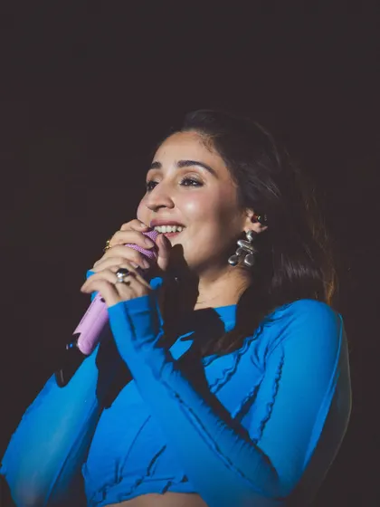 A beautiful close-up of Dhvani, smiling as she sings. This shot captures the joy she feels on stage, and the outfit is part of that expression.