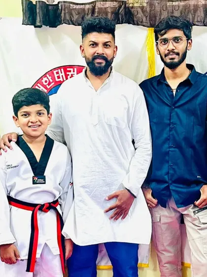 A student celebrates his new red and black belt.
