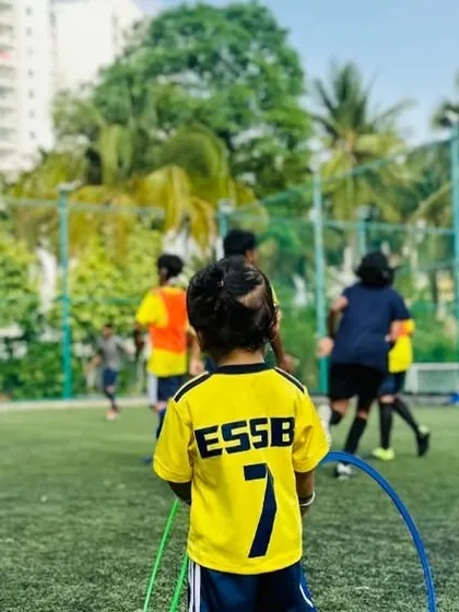 A young player watches his teammates, ready for his turn. Our sessions are structured to keep all children engaged, whether they are actively in a drill or observing.