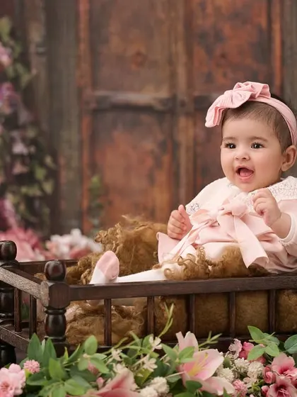 A classic baby portrait surrounded by flowers. The soft lighting and floral elements create a timeless and delicate look.