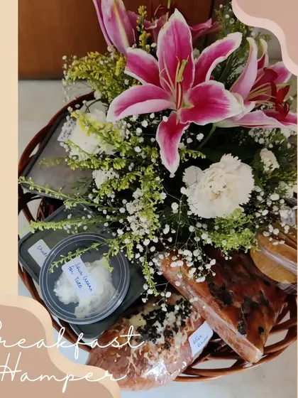 A beautifully arranged breakfast hamper, complete with a fresh flower bouquet, making it a perfect gift to start someone's day on a happy note.
