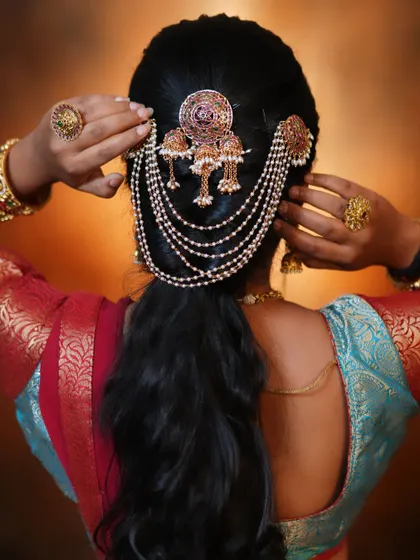 A model showcasing a modern, minimalistic hair accessory with pearl chains, great for a reception or sangeet.