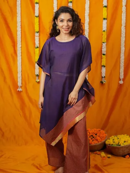 An asymmetrical kaftan-style kurta paired with palazzo pants. This modern silhouette combines comfort with a chic design, featuring a traditional border for a touch of ethnic flair.