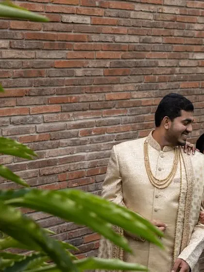 A romantic portrait of the engaged couple, framed by lush green leaves, as they share a quiet moment together.