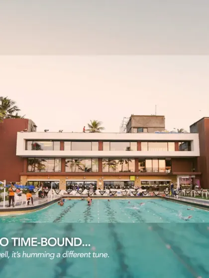 The modern, revitalized Otters Club humming with activity. The redesign opened up the poolside area and updated the facade with clean lines and large glass panels, transforming it into a contemporary and vibrant social hub.