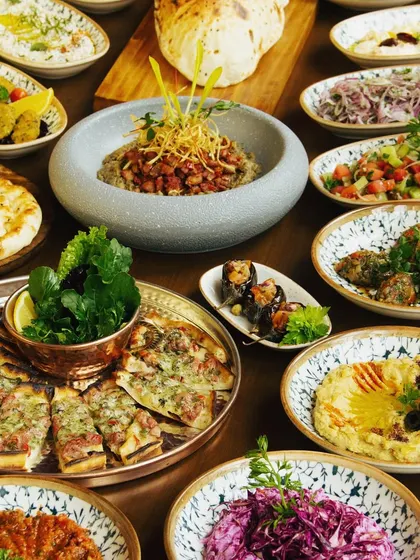 A grand Turkish feast. This spread of various mezzes, salads, and breads showcases the rich and diverse flavors of our Turkish menu.