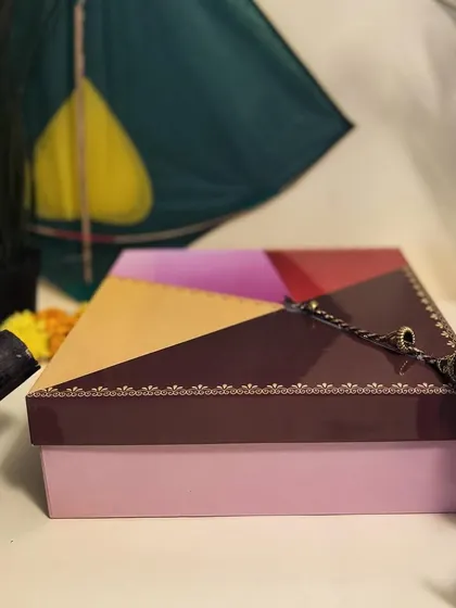 A close-up of our unique kite-shaped Sankranti box, which introduces our brand's new color palette. It's a fresh take on festive packaging.