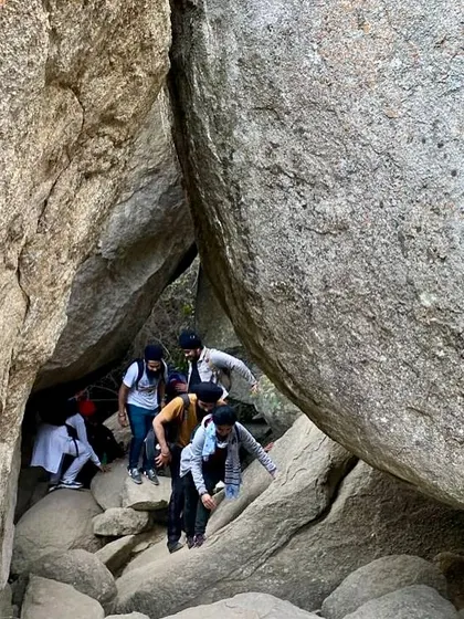 Navigating the narrow cave passages at Anthargange. This part of the trek requires teamwork and trust, making it an excellent team-building activity.