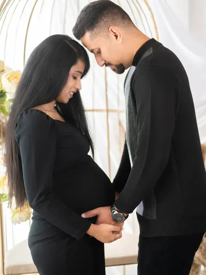 A tender forehead-to-forehead pose that speaks of intimacy and a shared future. It's a quiet, beautiful moment between two people about to become parents.