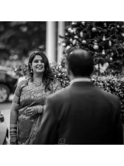 A candid black and white photo capturing the bride's happy expression as she looks at her partner. It’s these fleeting glances that tell the real story.