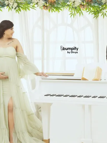 Composing a new melody. This shot from our grand piano maternity theme captures the couple in a romantic pose, celebrating the new life they are creating together.