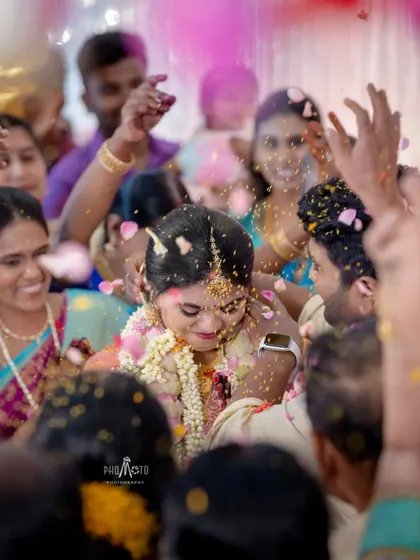 A close-up shot of the bride amidst a shower of pink petals, her face full of joy.