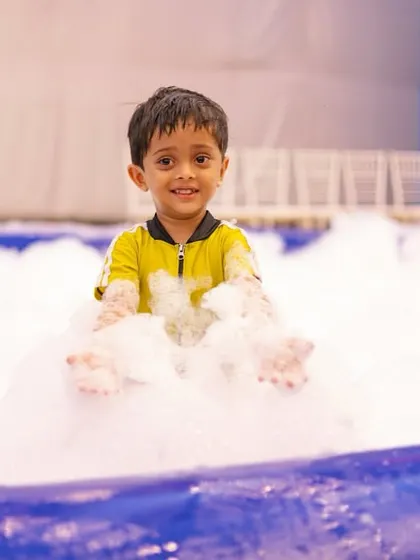 A party is all about the fun. For this pool party, we brought in a foam machine, and the look on this little one's face, surrounded by bubbles, is a perfect example of the pure, simple joy I aim to create.