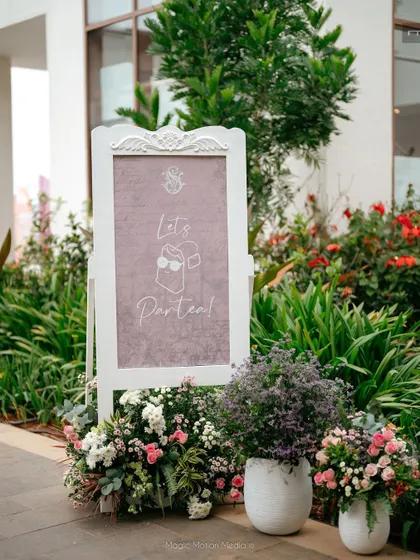 The 'Let's Partea!' welcome sign, surrounded by fresh flowers.