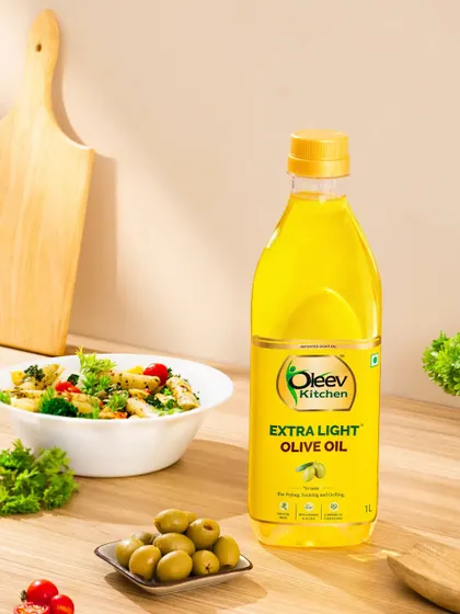 A vibrant, kitchen-ready setting for Oleev's Extra Light Olive Oil. Styled with a fresh pasta salad and ingredients, the shot is meticulously arranged to highlight the product’s appeal for everyday cooking.