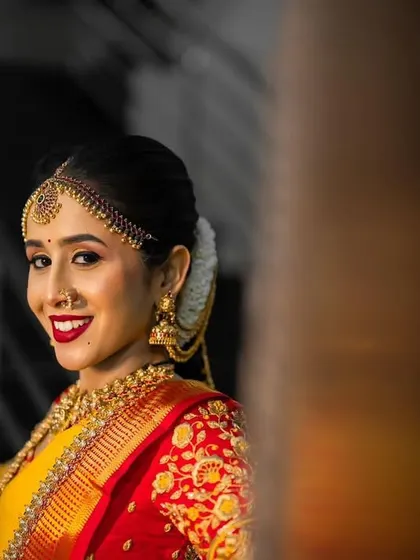 A lovely candid shot of the bride, capturing her happy smile and the rich colors of her wedding saree.