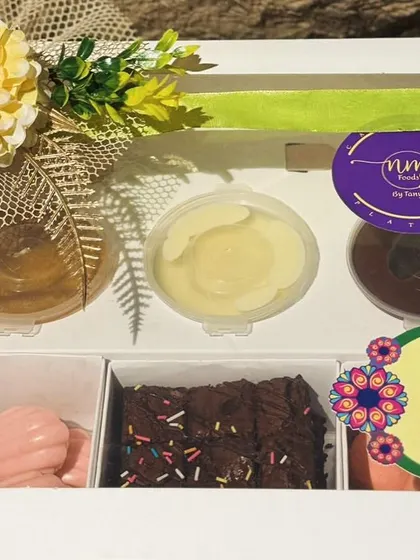 The Exotic Dessert Box, beautifully packaged with a "Happy Rakhi" sticker, making it the perfect sweet gift for festive occasions.