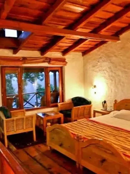 A cozy guest room with a wooden vaulted ceiling and large windows that frame the beautiful outdoor scenery.