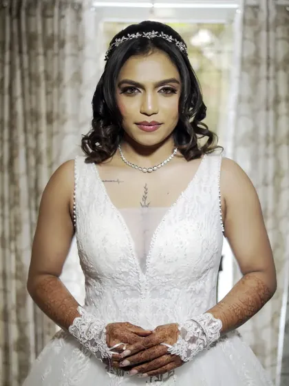 A serene and elegant portrait of the bride in her beautiful white wedding gown. Her calm demeanor and the classic style of her dress and tiara create a timeless and beautiful image.