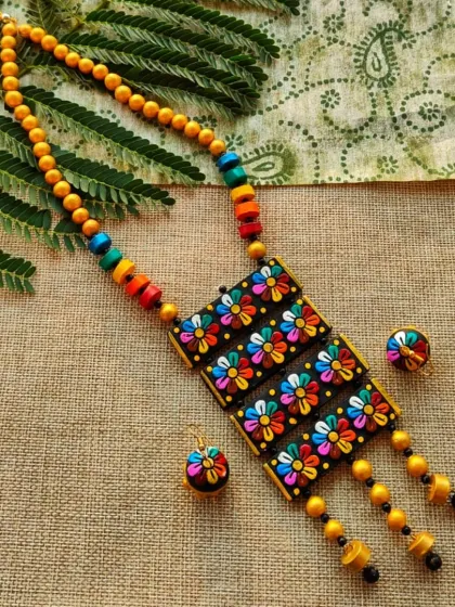 The full view of the rectangular floral necklace, showcasing its vibrant colors against a black background. This is a very eye-catching piece for any display.