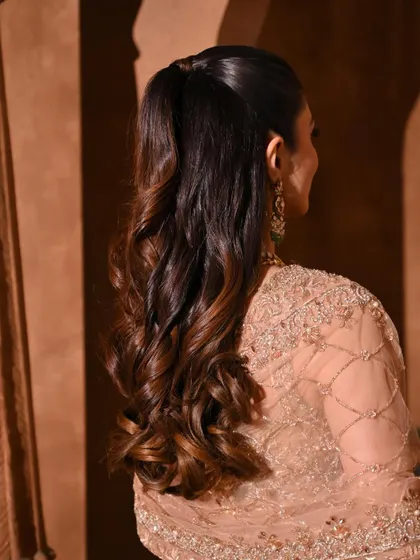 A half-ponytail with soft, cascading curls is a beautiful and versatile look for any pre-wedding event.
