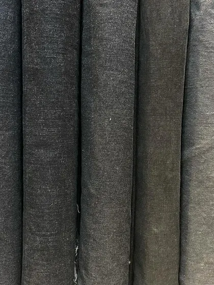 A collection of denim rolls in various shades of grey. From dark charcoal to light stone grey, you can find the perfect shade for your custom jeans or jacket.