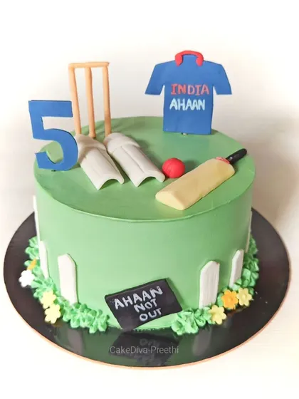 Bowl them over with this cricket-themed cake! It features a vibrant green pitch, fondant wickets, a bat, ball, and a custom jersey, all on a red velvet cake.