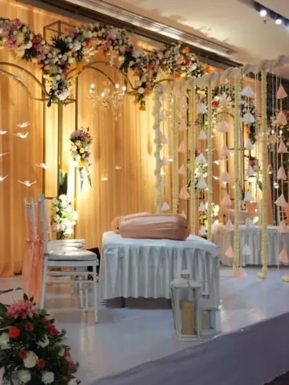 This setup shows another configuration for the reception stage, with hanging floral strings and elegant white chairs, demonstrating our ability to customize designs.