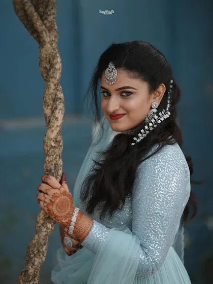 A stunning portrait of the bride, her smile and elegant jewelry shining. The composition uses a prop to add an interesting foreground element.