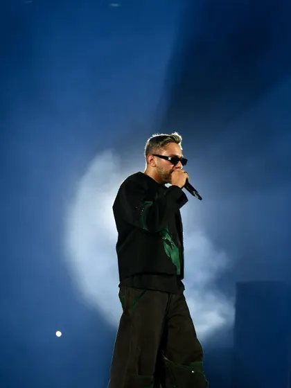 A profile shot of Yo Yo Honey Singh against a soft blue background, creating a cool, iconic silhouette.
