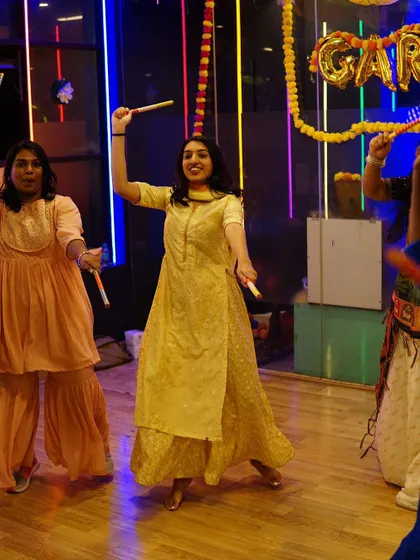 A participant confidently leading her row in a Dandiya dance. We empower beginners to become stars on the dance floor.